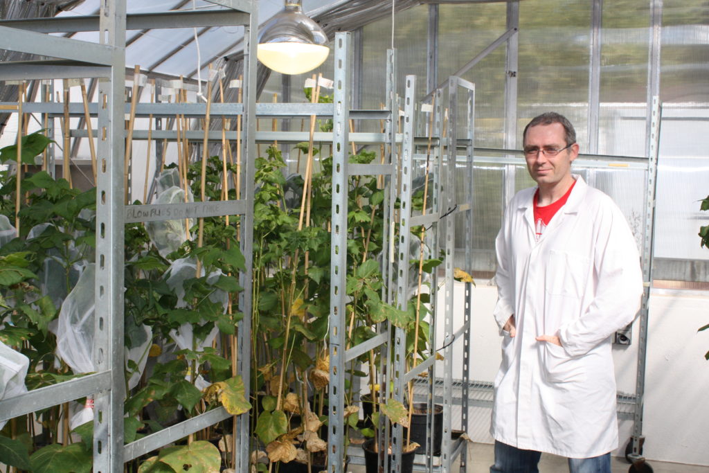 man in greenhouse wearing lab coat